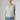 Front view of the Boheme Cashmere Top Salvia in soft sage green highlighting the textured knit, sleeveless silhouette, and elegant scoop neckline.