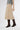 Side view of soft safari suede midi skirt showing smooth structure and elegant fall along the body
